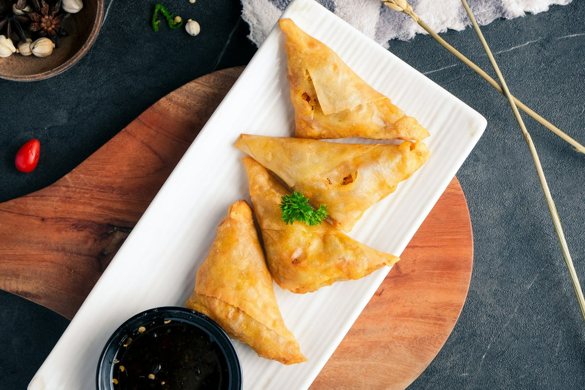 Crispy samosas served with dipping sauce (photo: Iqbal Pohan, Unsplash)